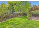 Lush green backyard featuring a wooden deck and wooden fence at 744 Owl Dr, Louisville, CO 80027