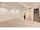 Finished basement with neutral carpet, stairway, and bathroom access at 744 Owl Dr, Louisville, CO 80027