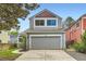 Two-story home with gray siding, a gray garage door, and a concrete driveway at 744 Owl Dr, Louisville, CO 80027