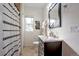 Bright bathroom featuring a vanity with a marble countertop and modern fixtures, complemented by a decorative shower curtain at 3233 W 29Th Ave, Denver, CO 80211
