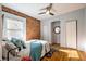 Stylish bedroom featuring a brick wall, hardwood floors, and closet space at 3233 W 29Th Ave, Denver, CO 80211