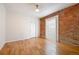 Spacious bedroom featuring exposed brick wall, refinished floors, and a large window allowing for an abundance of natural light at 3233 W 29Th Ave, Denver, CO 80211