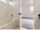 Bright tiled bathtub with a view into the carpeted adjacent bedroom at 3853 Orleans Ct, Denver, CO 80249