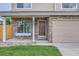 Front exterior of home showcasing tan siding, stonework, and a two-car garage at 3853 Orleans Ct, Denver, CO 80249