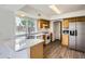 Bright kitchen featuring white appliances, wooden cabinets, and hardwood floors at 3853 Orleans Ct, Denver, CO 80249