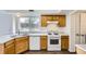 Kitchen featuring white appliances, wooden cabinets, and hardwood floors at 3853 Orleans Ct, Denver, CO 80249