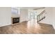Open-concept living area featuring hardwood floors, fireplace, and staircase at 3853 Orleans Ct, Denver, CO 80249