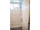 Bright white bathroom with a tub, shower, and window with flower pots on the window sill at 7472 E 28Th Ave, Denver, CO 80238