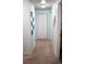 Long hallway featuring neutral carpet, light blue walls, and white doors and trim at 7472 E 28Th Ave, Denver, CO 80238