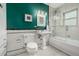 Updated bathroom features a glass enclosed shower-over-tub, classic fixtures, and green accent wall at 1138 E 14Th Ave # 12, Denver, CO 80218