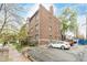Brick building with many windows, parking area, and mature trees on a sunny day at 1138 E 14Th Ave # 12, Denver, CO 80218