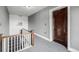 Hallway with stairs, neutral carpet, and a wooden door marked '12' in an apartment building setting at 1138 E 14Th Ave # 12, Denver, CO 80218