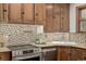 Kitchen featuring stainless steel appliances, granite countertops, and wooden cabinets with a tile backsplash at 1138 E 14Th Ave # 12, Denver, CO 80218