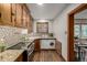 Bright kitchen has wooden cabinets, stainless appliances, granite countertops, and stackable washer and dryer at 1138 E 14Th Ave # 12, Denver, CO 80218