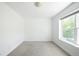 Bright bedroom featuring neutral carpet, white walls and trim, and a sunlit window at 4395 E Jewell Ave # 3, Denver, CO 80222