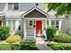 Close-up of an inviting townhome entrance with a bright red door and manicured landscaping at 4395 E Jewell Ave # 3, Denver, CO 80222