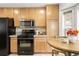 Bright kitchen featuring stainless steel appliances, granite counters, and light wood cabinets at 4395 E Jewell Ave # 3, Denver, CO 80222