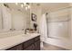 Well-lit bathroom featuring a large mirror, vanity with drawers, and a bathtub with shower at 3578 Tranquility Trl, Castle Rock, CO 80109