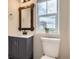 Modern bathroom featuring a gray vanity, decorative mirror, and natural light from a window at 3578 Tranquility Trl, Castle Rock, CO 80109