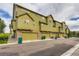 Street view of townhomes with green siding, stone accents, and attached garages at 3578 Tranquility Trl, Castle Rock, CO 80109