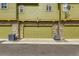 Townhome garages with matching green doors, stone accents, and individual air conditioning units at 3578 Tranquility Trl, Castle Rock, CO 80109