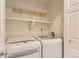 Bright laundry room features side by side washer and dryer, shelving, and a nearby doorway at 3578 Tranquility Trl, Castle Rock, CO 80109