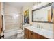 Bathroom featuring a wood vanity with marble countertop, a shower and bathtub combination, and neutral paint colors at 11652 Camp Eden Rd, Golden, CO 80403