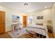 Bedroom featuring a metal bed frame, a white nightstand, a writing desk, and a charming window with sheer curtains at 11652 Camp Eden Rd, Golden, CO 80403