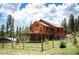 Stunning wood home with a large deck and stone foundation, nestled in a serene, green forested setting at 11652 Camp Eden Rd, Golden, CO 80403