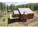 Attractive wooden home featuring a deck, stone accents, and lush green lawn, perfect for outdoor living at 11652 Camp Eden Rd, Golden, CO 80403