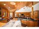 Log-walled living room showcases an island and open concept with lots of seating and natural light at 11652 Camp Eden Rd, Golden, CO 80403