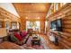 Log walled living room with vaulted ceilings, wood floors, comfortable seating, and mountain views at 11652 Camp Eden Rd, Golden, CO 80403