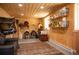 Spacious tack room with wood paneling, sofa, rug, saddle and equestrian equipment storage at 11652 Camp Eden Rd, Golden, CO 80403