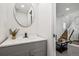 Bathroom featuring a modern sink, a round mirror, and luxury vinyl plank flooring at 20 1/2 S Sherman St, Denver, CO 80209