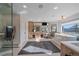 Bright bathroom featuring a glass shower, soaking tub, vanity, and views of the trees at 4125 Aspen Ln, Evergreen, CO 80439