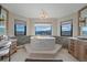 Serene bathroom with a soaking tub, natural light, and views of the mountains at 4125 Aspen Ln, Evergreen, CO 80439