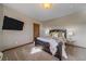 Bedroom with dark wood furnishings, neutral carpet and decor, and a large wall-mounted TV at 4125 Aspen Ln, Evergreen, CO 80439