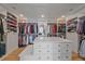 Walk-in closet featuring custom shelving, drawers, and a marble island at 4125 Aspen Ln, Evergreen, CO 80439