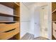 Organized walk-in closet featuring built-in shelving and a glimpse of an attached bathroom at 5771 W 92Nd Ave # 335, Westminster, CO 80031