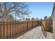 Private wooden deck with wood railing offers an outdoor space with mature trees overhead at 5771 W 92Nd Ave # 335, Westminster, CO 80031