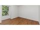 This bedroom includes a large window, wood flooring, and bright white walls at 2013 S Helena St # B, Aurora, CO 80013