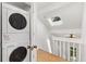 Upstairs hallway with skylight, wooden floors and stacked washer/dryer at 2013 S Helena St # B, Aurora, CO 80013