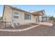 Back exterior and patio with brick trim, overlooking a fenced backyard with a field beyond at 5506 Malta St, Denver, CO 80249