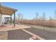 View of a backyard patio overlooking a field with a black wrought iron fence at 5506 Malta St, Denver, CO 80249