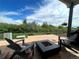 Covered patio with comfortable seating and a fire pit, overlooking a green yard with mature trees at 5506 Malta St, Denver, CO 80249