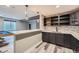 Bar with stylish gray cabinetry and countertops, plus an adjacent pool table in the basement at 5506 Malta St, Denver, CO 80249