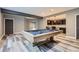 Finished basement with a pool table and a stylish bar area with modern lighting at 5506 Malta St, Denver, CO 80249