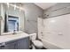 Bathroom features gray vanity, a tub with shower, and modern fixtures at 5506 Malta St, Denver, CO 80249