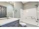 Bathroom featuring white subway tile, gray cabinets, and a tub/shower combo at 5506 Malta St, Denver, CO 80249
