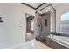 Bathroom featuring a glass shower with rainfall shower head, built in shower seat, and pebble floor at 5506 Malta St, Denver, CO 80249